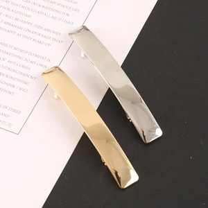 Detail view of silver and gold rectangular metallic hair clips with polished mirror finish