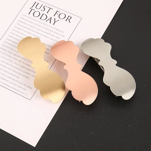 Detailed macro view of three matte alloy hair clips in gold, rose gold and silver