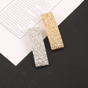 Détails de barrettes rectangulaires dorées et argentées avec texture effet pierre taillée