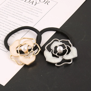 Detailed view of camellia hair ties with faux pearls and gold and silver metallic edges