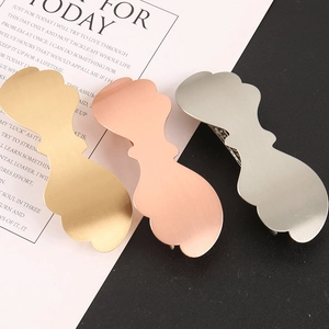 Detailed macro view of matte metal hair clips in gold, rose gold and silver cloud shapes