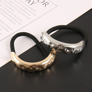 Detail showing liquid metal texture hair ties in silver and gold with hammer pattern