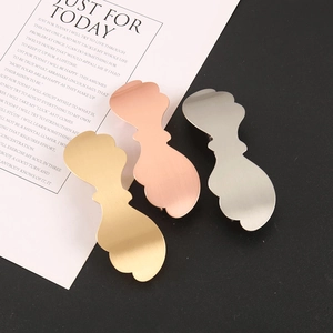 Detailed macro of minimalist wavy metal hair clips in gold, rose gold and silver finish