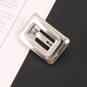 Détail d'un clip métallique rectangulaire argenté creux avec une finition polie miroir