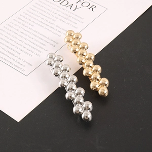 Detail of stacked metal ball bead hair clips in polished gold and silver finish