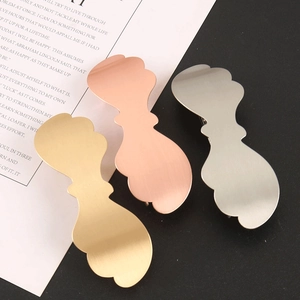 Macro detail of three-color alloy hair clips with minimalist wave design and matte finish