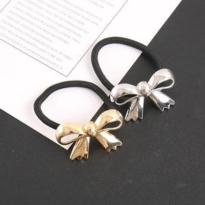 Detail of elegant gold and silver metallic bow hair ties with elastic black bands
