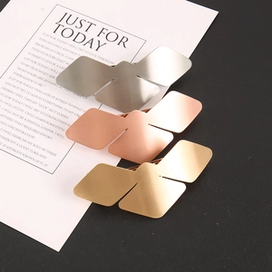 Detailed close-up of geometric bird-shaped metal hair clips in gold, silver, and rose gold