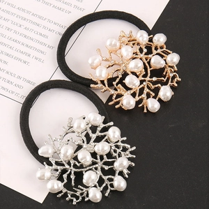 Detail of coral-shaped gold and silver alloy hair ties with white pearls and crystals