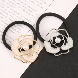 Close-up of luxury camellia hair ties with hollow metal frames and pearl centers
