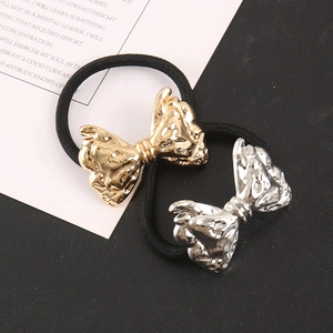 Detail showing gold and silver bow-knot metal hair ties with elastic black cords