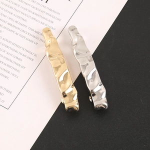 Minimalist liquid metal hair clip with irregular lava texture in gold and silver finishes