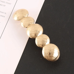 Golden hair clip featuring five round dome metal blocks with fine brushed texture finish