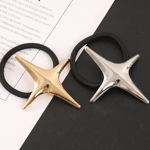 Détail des charms étoiles en métal doré et argenté sur élastiques à cheveux noirs
