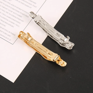 Macro detail of glossy gold and silver metal hair clips with spring tension design