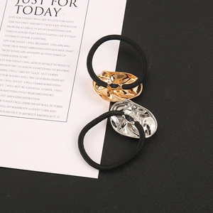 Detailed macro view of gold and silver metallic oval hair ties on high elasticity black bands