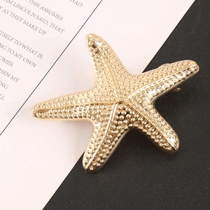 Fermaglio creativo a stella marina dorata con texture granulata e stile oceanico