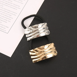 Detailed macro view of gold and silver square alloy hair ties with ripple texture effects