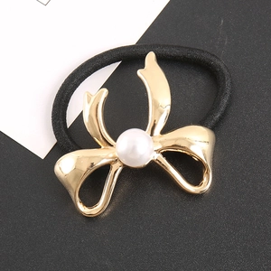 Élastique à cheveux avec un nœud doré poli et une perle blanche centrale élégante