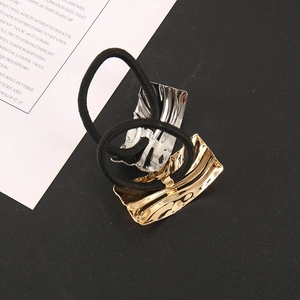 Close-up of wavy metal gold and silver ponytail holders with black elastic hair bands
