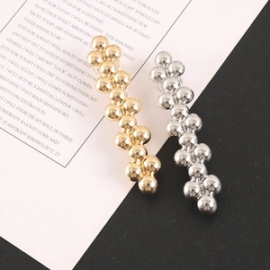 Close-up of elegant gold and silver beaded bubble hair clips with a high-polished mirror finish