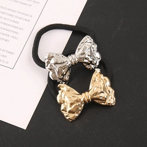 Detail of gold and silver metallic bow hair ties with embossed satin texture and black elastic