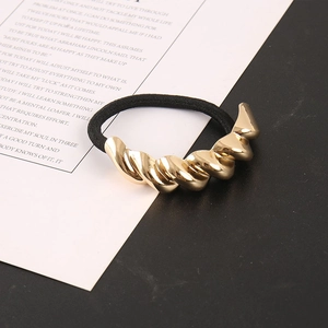 Detail eines hochelastischen schwarzen Haargummis mit polierter goldener Spiralverzierung
