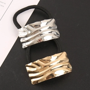 Detail of square alloy hair ties with wavy metal texture in gold and silver plating