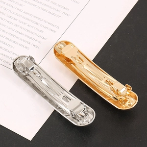 Macro view showing the spring clip mechanism of gold and silver alloy hairpins