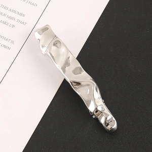 Macro detail of silver alloy hair clip featuring modern minimalist crinkled texture design