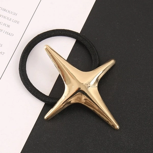 Détail d'un élastique à cheveux noir avec un pendentif étoile à quatre branches doré