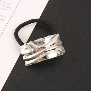 Minimalist silver wavy metal hair tie with black high-elastic band on bicolored background