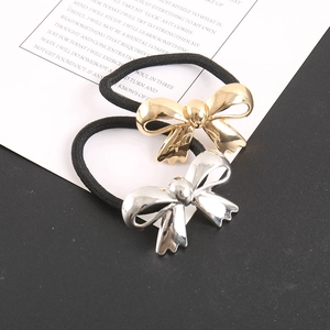 Detail view of gold and silver metallic bow hair ties with high-elastic black bands