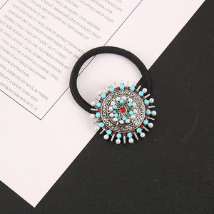 Détail d'un élastique à cheveux bohème avec pendentif rond en alliage et perles colorées