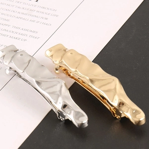 Detailed shot of gold and silver alloy hair clips with unique liquid metal wavy texture