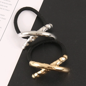Detail view of minimalist gold and silver X-shaped geometric hair ties on elastic bands