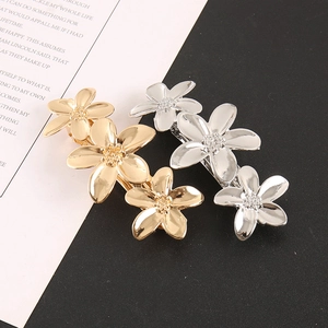 Vue détaillée de barrettes à fleurs en métal or et argent avec finition miroir poli