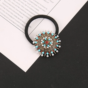Détail de l'élastique à cheveux bohème avec perles turquoise et strass rouge poli