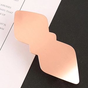 Pince à cheveux géométrique en or rose avec texture métallique brossée et design losange