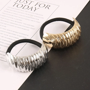 Detail of gold and silver textured metal tube hair ties with black elastic bands