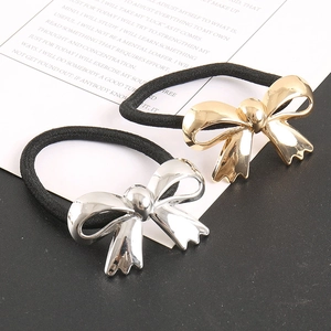 Close-up of gold and silver metallic bow ponytail holders with black elastic bands