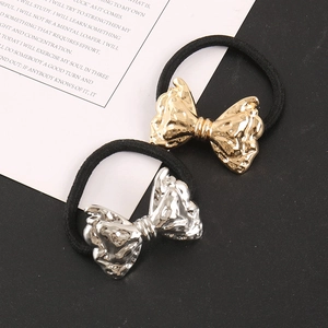 Detailed close-up of gold and silver textured metal bow hair ties on display cards
