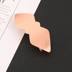Gros plan d'une pince à cheveux géométrique en or rose avec finition en métal mat givré