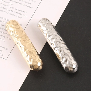 Close-up of hammered textured metal hair clips in gold and silver plating