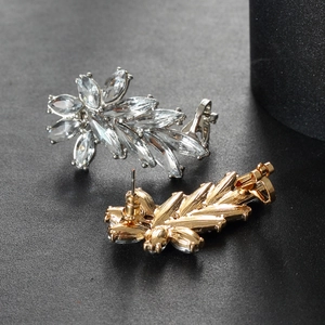 Dettaglio di orecchini ear climber in argento e oro con cristalli dal taglio marquise