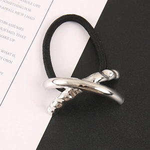 Detail shot of silver crisscross metal hair tie with irregular hammered texture finish
