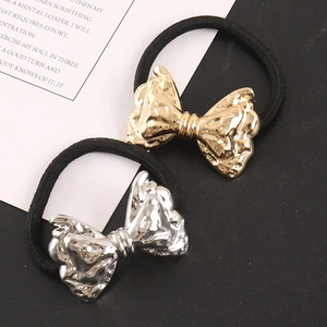 Detail view of punk style metallic bow hair ties in gold and silver finishes