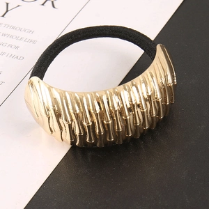Detail of gold bamboo texture metal ornament on a high-elastic black ponytail holder