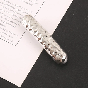 Polished silver alloy hair clip with hammer texture on a diagonal background