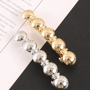 Détail de barrettes à cheveux en métal doré et argenté avec design géométrique chic